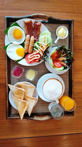 een dienblad met ontbijtproducten met eieren en toast bij La Mai Hotel in Chiang Mai