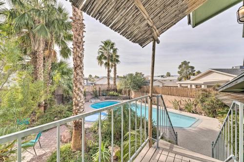 a balcony with a view of a swimming pool and palm trees at Vegas Oasis Home with Pool and Spa 7 Miles to Strip in Las Vegas