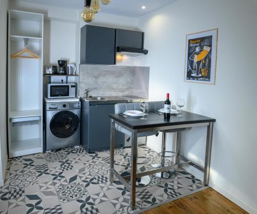 une cuisine avec une table avec des verres à vin dessus dans l'établissement Lumineux appartement,3' de la gare, Terrasse, équipé fibre,bonsejour19, à Tulle