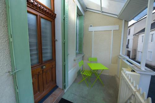 Zimmer mit einem grünen Tisch und einer Tür in der Unterkunft Lumineux appartement, 3min de la gare, équipé fibre,bonsejour19 in Tulle
