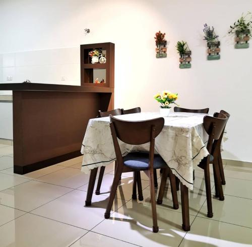 a dining room table with four chairs and a white table at Holiday Homestay Seremban in Seremban