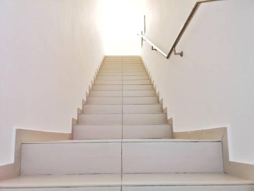 a staircase in a white building with a stair case at Holiday Homestay Seremban in Seremban