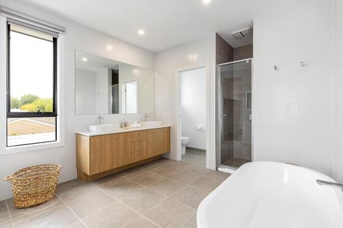 ein weißes Badezimmer mit einem Waschbecken und einem Spiegel in der Unterkunft Maison Magnolia in Rye