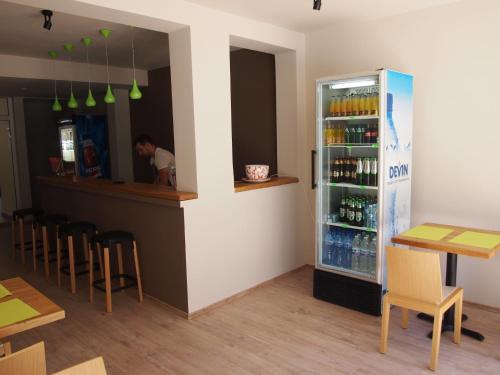 a bar in a restaurant with a refrigerator filled with drinks at Hotel Milan in Primorsko