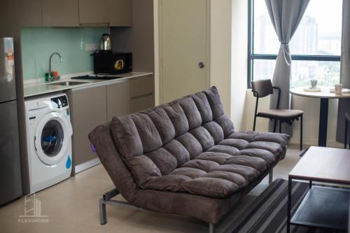 a living room with a couch and a kitchen at 9am-5pm, SAME DAY CHECK IN AND CHECK OUT, Work from Home, Comfy & Quiet Tamarind Suites-Cyberjaya by Flexihome-MY, in Cyberjaya