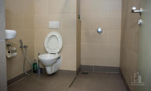 a bathroom with a white toilet in a stall at 9am-5pm, SAME DAY CHECK IN AND CHECK OUT, Work from Home, Comfy & Quiet Tamarind Suites-Cyberjaya by Flexihome-MY, in Cyberjaya