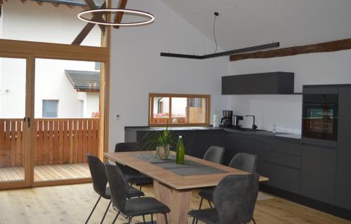 a kitchen and dining room with a wooden table and chairs at Bachmannhof in Feldthurns
