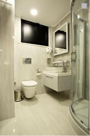 ein Badezimmer mit Toilette, Waschbecken und Dusche in der Unterkunft Endglory Hotel in Çorlu