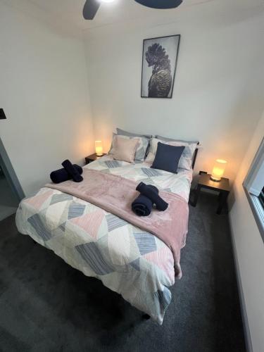 um quarto com uma cama e duas lâmpadas em duas mesas em Lakeside Residence em Raymond Terrace