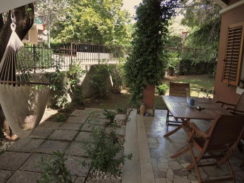 a patio with a wooden table and chairs at B&B Porto Del Bivio in Duino