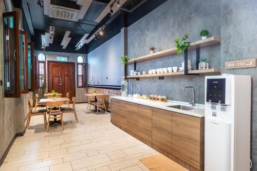 a kitchen with a sink and a table with chairs at The NINES HOTEL Malacca in Malacca