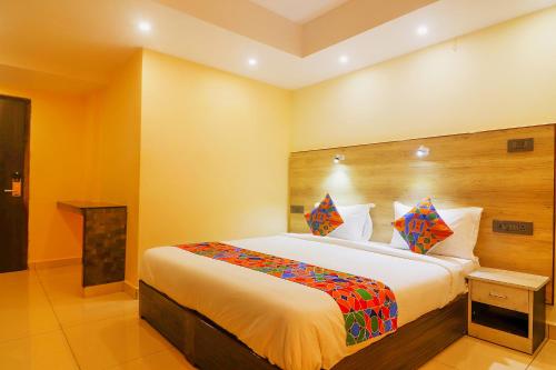 ein Schlafzimmer mit einem großen Bett in einem Zimmer in der Unterkunft FabHotel Surya Grand I in Vijayawāda