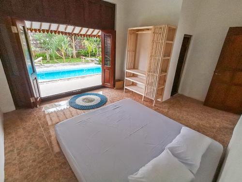 een slaapkamer met een bed en een deur naar een zwembad bij Ndalem Treko Homestay in Magelang