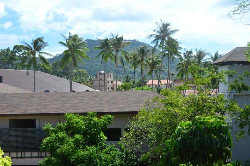 a view of palm trees and houses in a city at Bonny Hotel 4 Floors No Elevator in Lamai