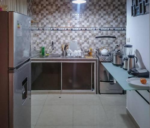 a kitchen with a stainless steel refrigerator and a sink at Full apartment independent entrance, services included in Lima