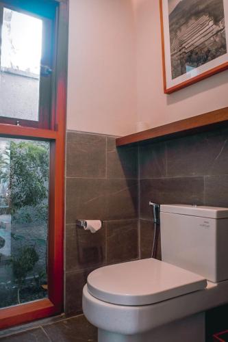 a bathroom with a toilet and a window at Sampatti Villas in Seminyak