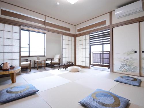 a living room with large windows and mats on the floor at Shirahama no Yado Daigo in Shirahama
