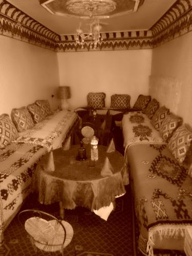 a living room with two beds and a table at Gte Tawada - Haut-atlas - Room for 2 people in Ikhf nʼIghir