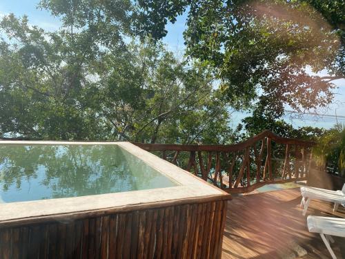 a swimming pool on a deck with a wooden fence at Xoot KaAna villa Amanecer in Bacalar