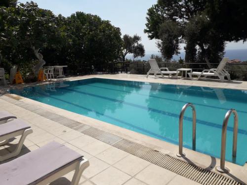 een groot zwembad met stoelen en een tafel bij ASIA APART HOTEL in Kuşadası