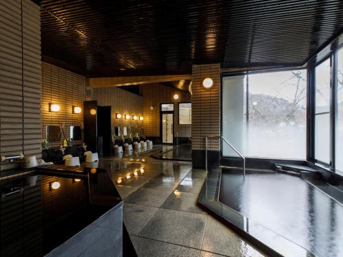 a large room with a swimming pool in a building at Motoyu Ishiya in Kanazawa