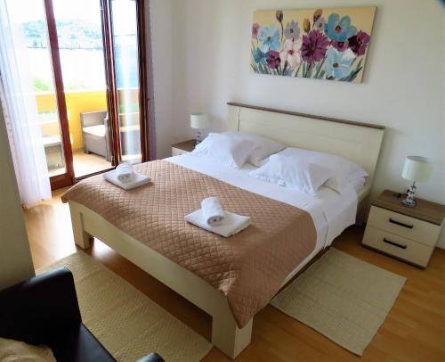 ein Schlafzimmer mit einem Bett mit zwei Handtüchern darauf in der Unterkunft Apartment by the sea and with beautiful view, 2 bedrooms, 4 persons in Kali