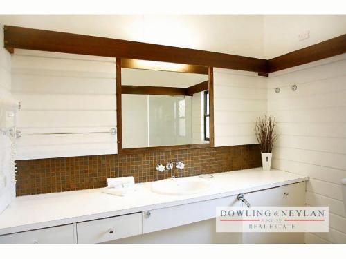 a bathroom with a sink and a mirror at Little Cove Townhouse 3 Pandanus Street 14 in Noosa Heads