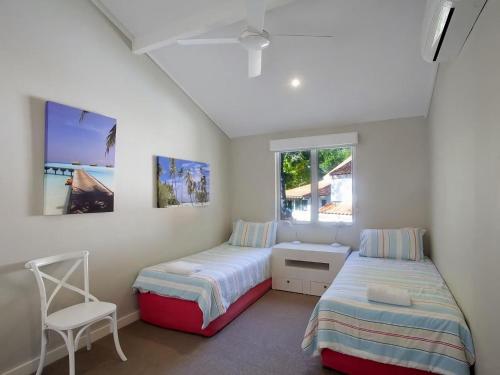 a bedroom with two beds and a chair in it at Little Cove Townhouse 9 Pandanus Street 14 in Noosa Heads