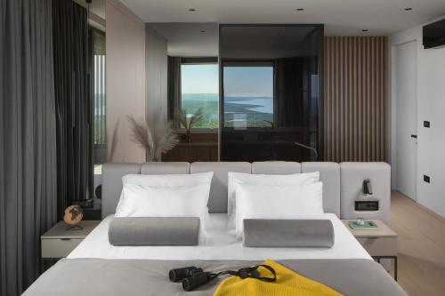 a bedroom with a large bed with a yellow bag on it at Villa Panoramica in Koromačno