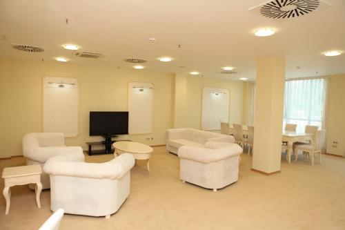 a waiting room with chairs and a table and a tv at Arena Hotel Kur in Mingachevir