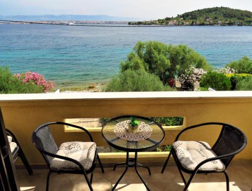 a table and chairs on a balcony overlooking the water at Apartment for 4 persons, by the sea and with beautiful view in Kali