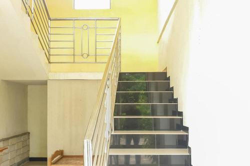 a staircase in a building with a door at Bromo 22 Homestay Syariah near Terminal Bayuangga Probolinggo Mitra RedDoorz in Pilang