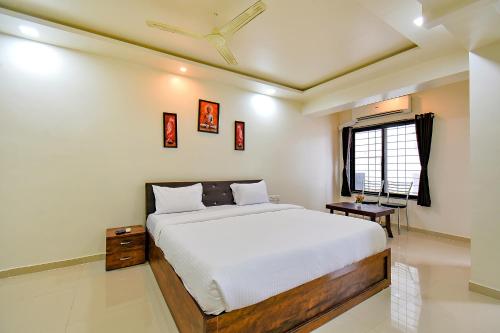 a bedroom with a white bed and a window at FabHotel White House - Nr Sinhagad speciality Hospital in Pune