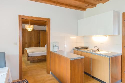eine Küche mit einem Waschbecken und ein Zimmer mit einem Bett in der Unterkunft City Life 2 by Alpenidyll Apartments in Schladming
