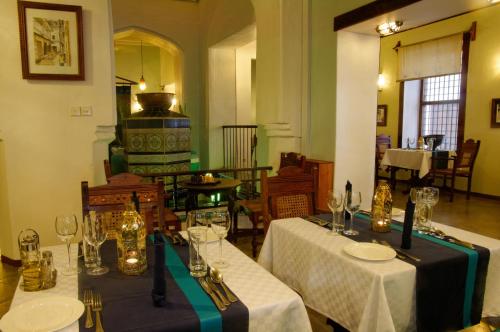 a dining room with two tables with wine glasses at Zanzibar Palace Hotel in Zanzibar City