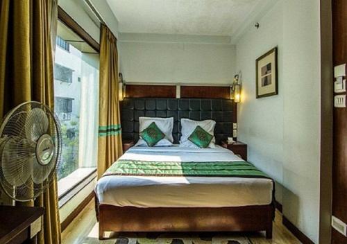 a bedroom with a bed and a window at The CORPORATE in Kolkata