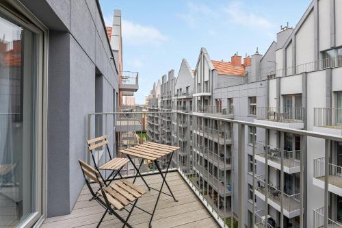 two chairs and a table on a balcony with buildings at GRANO APARTMENTS Gdańsk Old Town SPA & Wellness - GRANO APARTMENTS Gdańsk Residence SPA & Wellness in Gdańsk