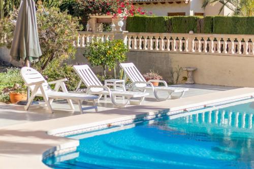 three chairs and a swimming pool in a yard at Villa Cucarres in Calpe
