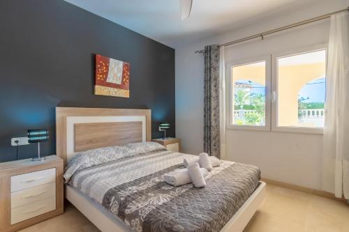 a bedroom with a large bed and a window at Villa Cucarres in Calpe