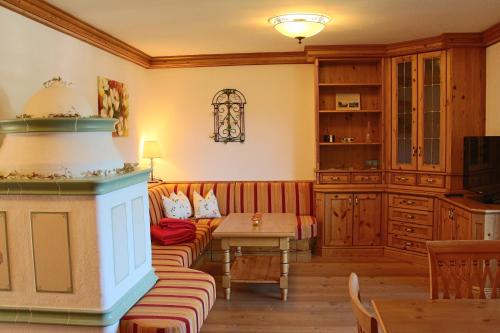 un soggiorno con un divano e un tavolo di Ferienwohnung Schossleitner - der Wohlfühl-Ansitz am Wolfgangsee mit Weitblick a Sankt Gilgen
