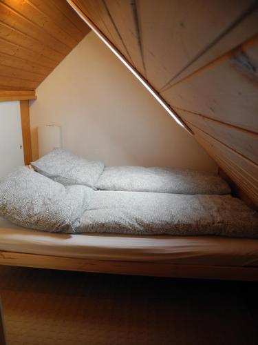 Bett in einem Zimmer mit Holzdecke in der Unterkunft Apartment Yvonne in Eimeldingen