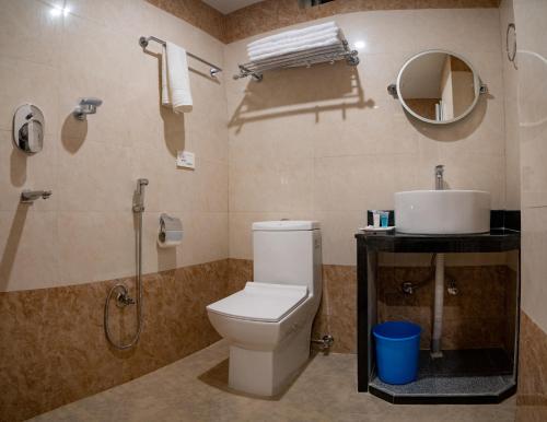 a bathroom with a toilet and a shower and a sink at Hotel Satkar Pvt Ltd in Pokhara