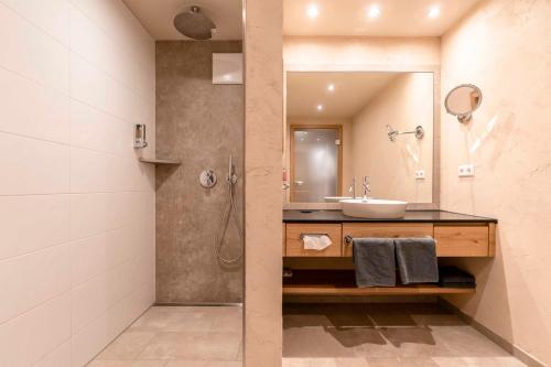 a bathroom with a sink and a shower at Hotel Restaurant Waldsägmühle in Pfalzgrafenweiler