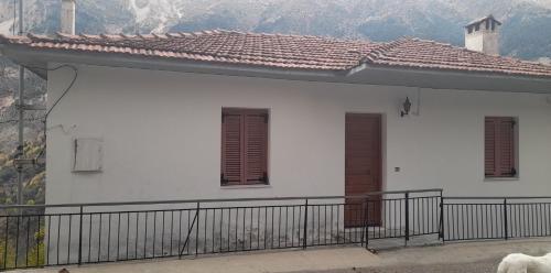 a white house with brown shutters and a balcony at Aetofolia Melissourgoi in Melissourgoi