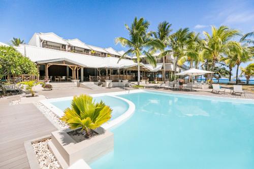 - une piscine en face d'un complexe avec des palmiers dans l'établissement Le Peninsula Bay Beach Resort & Spa, à Blue Bay
