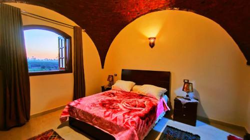 a bedroom with a bed with a large window at Tasneem Palace in Luxor