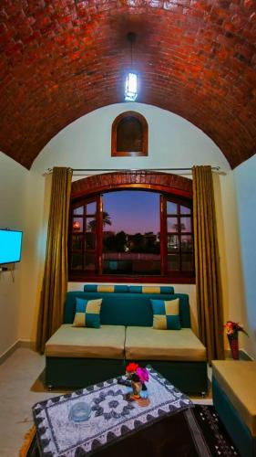 a living room with a couch and a window at Tasneem Palace in Luxor