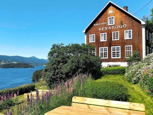 un banco de madera sentado frente a un edificio en 5 person holiday home in Lomen, en Løken