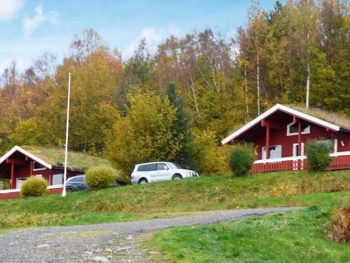 a white car parked in front of a red house at 6 person holiday home in VATNE in Vatne