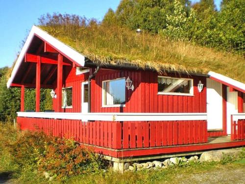 a red house with a grass roof on a hill at 6 person holiday home in VATNE in Vatne
